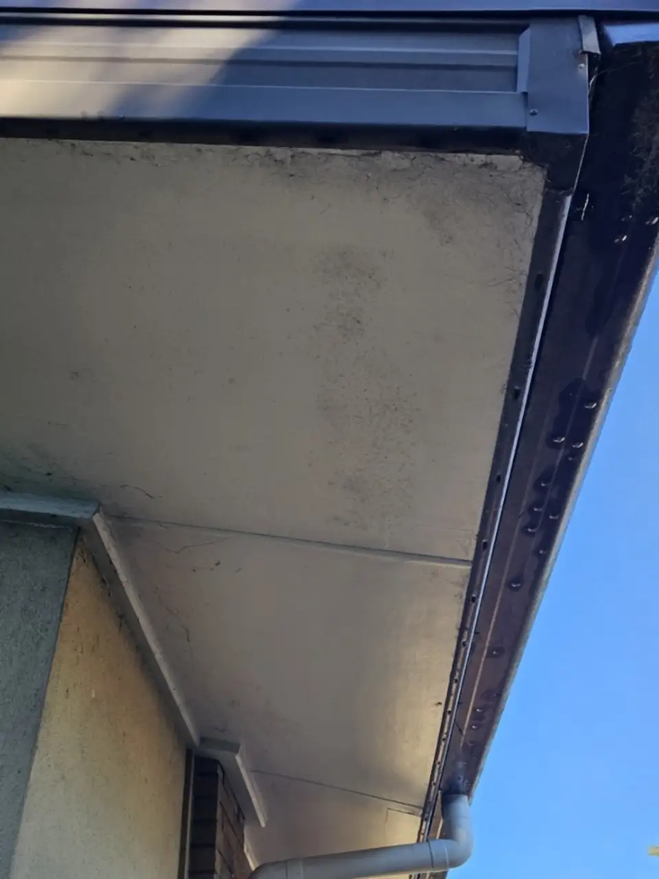 Before: The underside of the eaves, grey and streaked